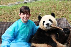 Children play with Panda at Chengdu Research and Base of Giant Panda